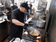 FILE - Tito Thepkaysone cooks up some pad Thai at &quot;Love &amp; Thai&quot; restaurant in Fresno, Calif., Wednesday, Dec. 20, 2023. The Thai restaurant was wrongfully accused of abusing a dog to turn it into meat, a false claim rooted in a racist stereotype.