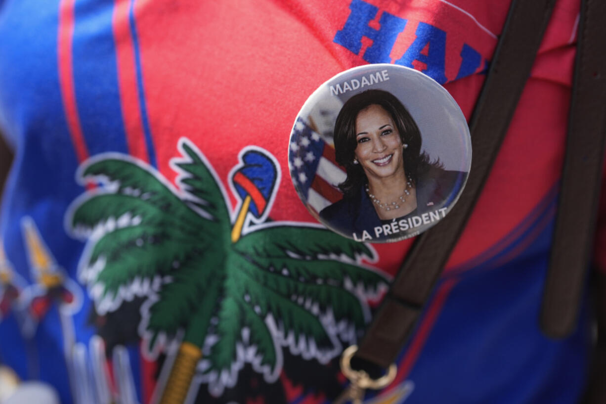 A woman wears a Haitian flag shirt and a pin supporting Democratic presidential nominee Vice President Kamala Harris, as members of South Florida&rsquo;s Haitian-American community listen to speakers during a rally to condemn hate speech and misinformation about Haitian immigrants, Sunday, Sept. 22, 2024, in North Miami, Fla.