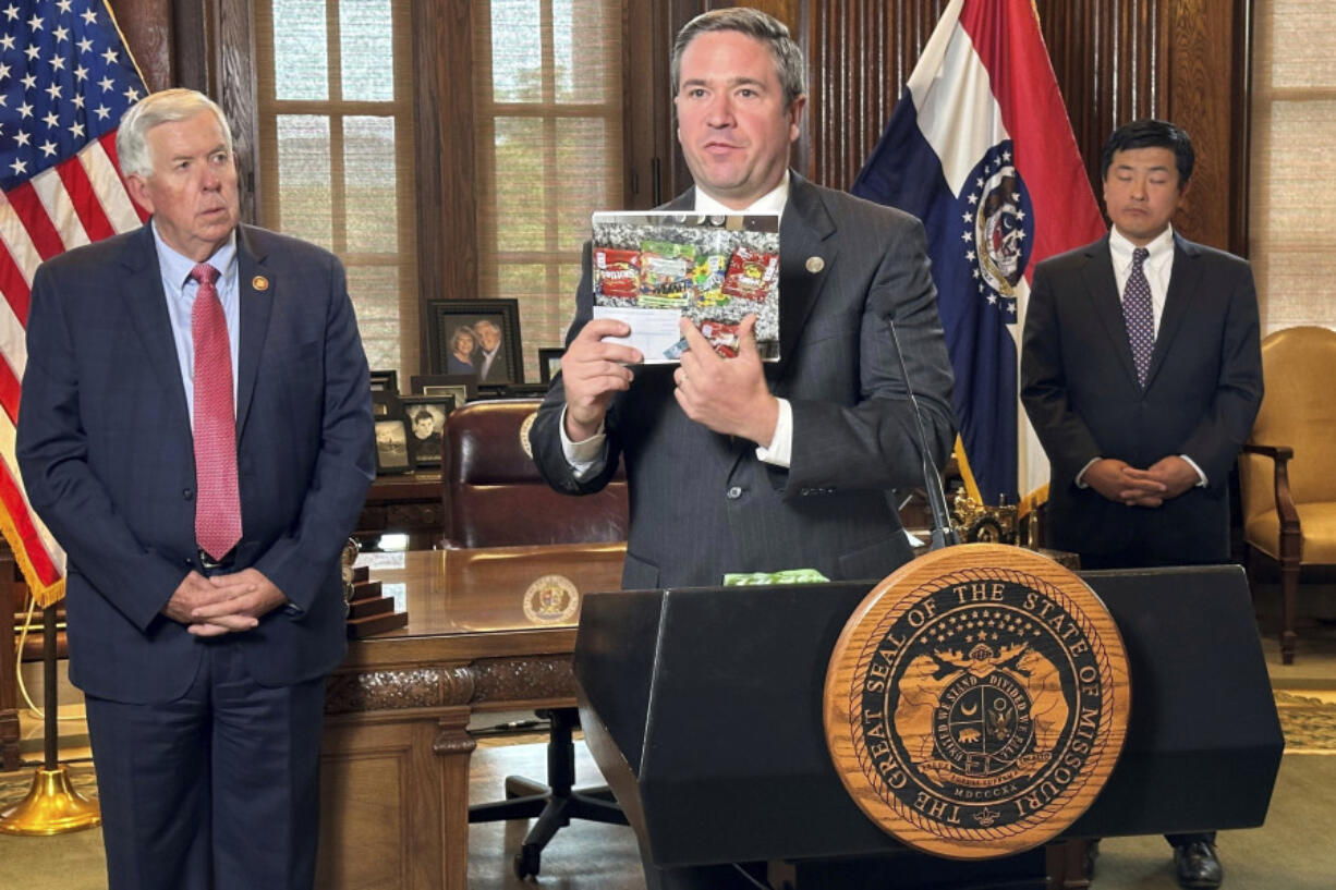 Missouri Attorney General Andrew Bailey holds up photos of candy-like products containing unregulated psychoactive cannabis ingredients that he says are being marketed to children during a press conference Tuesday, Sept. 10, 2024, at the governor&#039;s office at the state Capitol in Jefferson City, Mo. (AP Photo/David A.