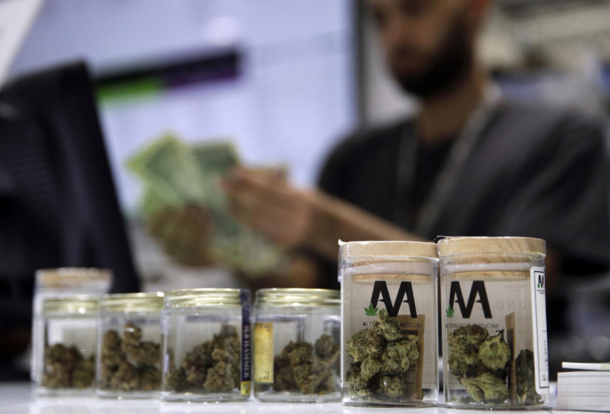 FILE - A cashier rings up a marijuana sale, July 1, 2017, at a cannabis dispensary in Las Vegas.