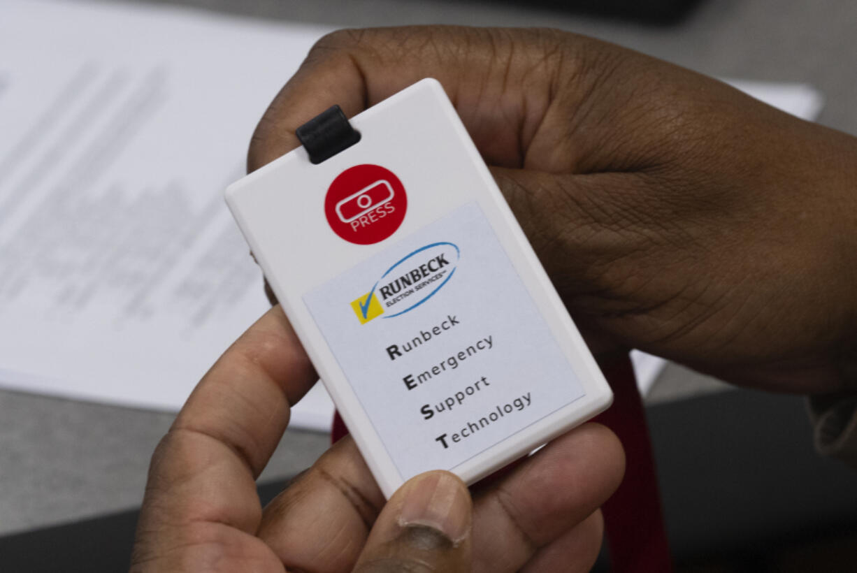 An attendee at an election security training session at Cobb County Emergency Management headquarters on in Marietta, Ga., on Aug. 23 examines a card with a panic button that will be used by county election workers.