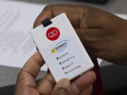 An attendee at an election security training session at Cobb County Emergency Management headquarters on in Marietta, Ga., on Aug. 23 examines a card with a panic button that will be used by county election workers.