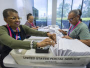 From left, Carol Hamilton, Cristo Carter and Cynthia Huntley prepare ballots to be mailed at the Mecklenburg County Board of Elections in Charlotte, N.C., Sept. 5, 2024.