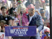 Republican presidential nominee former President Donald Trump holds his granddaughter Carolina Trump as he speaks at a campaign event at Wilmington International Airport in Wilmington, N.C., Saturday, Sept. 21, 2024.