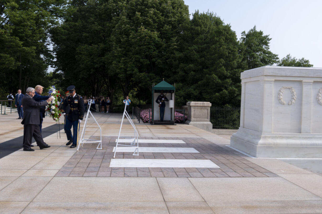 Bill Barnett, left, grandfather of Darin Taylor Hoover, and Republican presidential nominee former President Donald Trump place a wreath at the Tomb of the Unknown Solider in honor of Staff Sgt. Darin Taylor Hoover at Arlington National Cemetery, Monday, Aug. 26, 2024, in Arlington, Va.