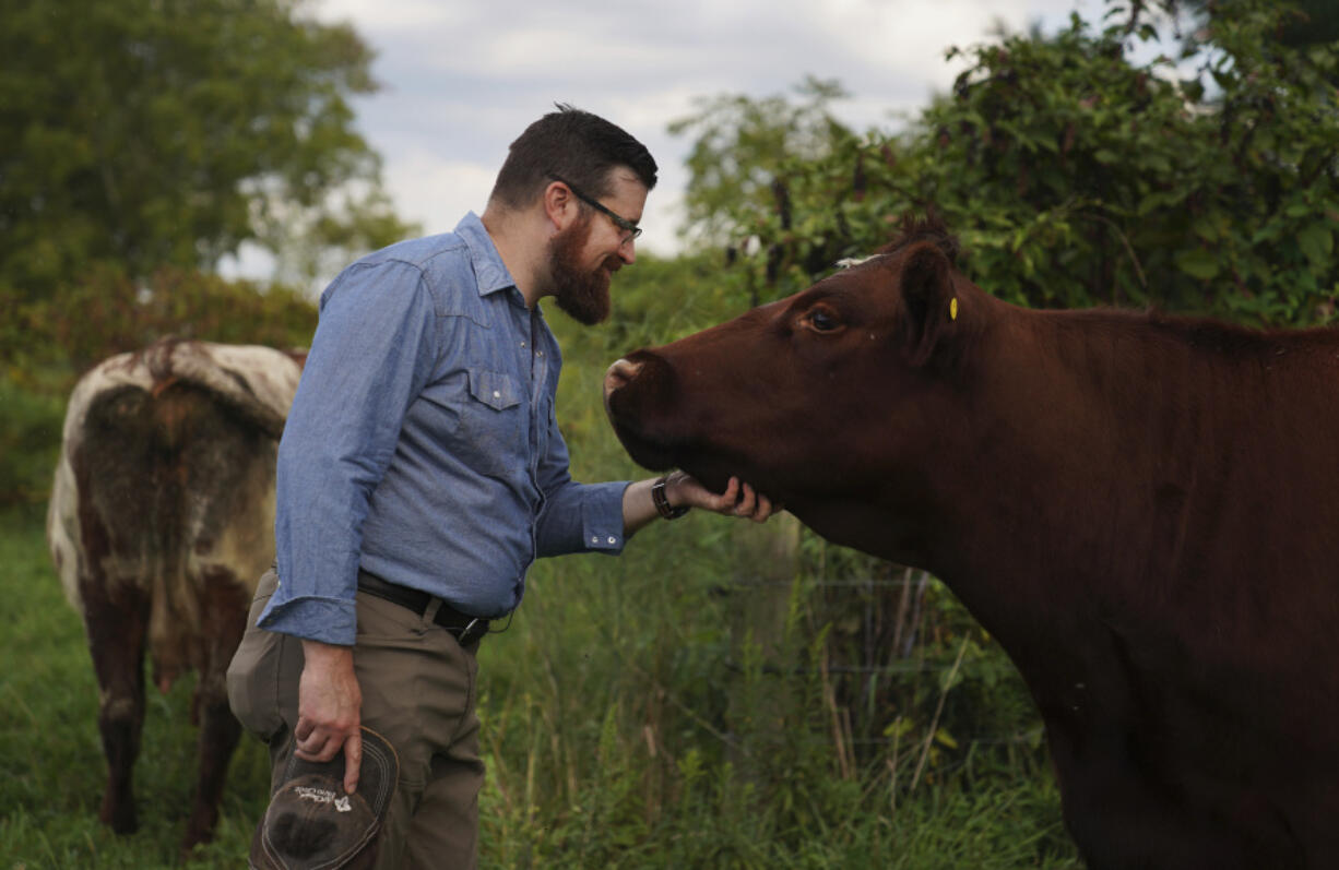 Farmer and Presbyterian pastor Lee Scott pets one of the cows Sept. 6 on his family farm, Laurel Oak Farm, in Butler, Pa.