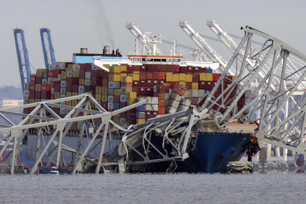 FILE - The cargo ship Dali is stuck under part of the structure of the Francis Scott Key Bridge after the ship hit the bridge, Tuesday, March 26, 2024, as seen from Pasadena, Md.