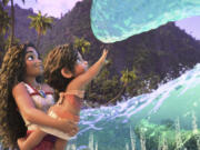 Moana, voiced by Auli&rsquo;i Cravalho, holding Simea, voiced by Khaleesi Lambert-Tsuda, in a scene from &ldquo;Moana 2.&rdquo; (Disney)