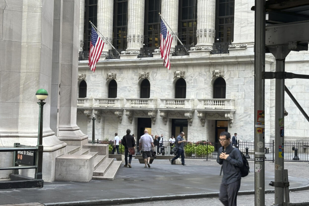 FILE - People pass the New York Stock Exchange, at rear, on Aug. 27, 2024, in New York.