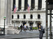 FILE - People pass the New York Stock Exchange, at rear, on Aug. 27, 2024, in New York.