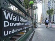 People pass the entrance for the Wall Street subway station on Tuesday, Sept. 2, 2024, in New York.