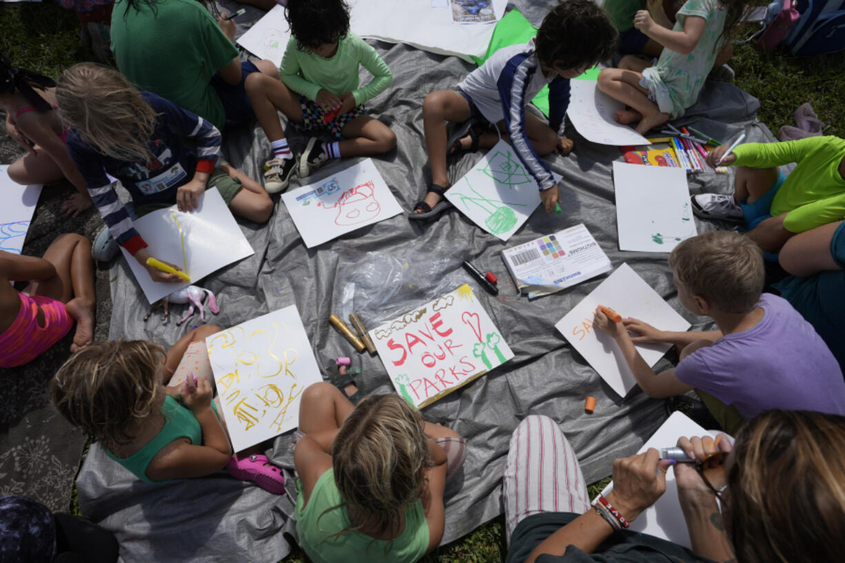 Children make signs as they attend a protest against Gov. Ron DeSantis&rsquo; plan to develop state parks with business ventures such as golf courses, pickleball courts and large hotels, during a demonstration at Oleta River State Park, Tuesday, Aug. 27, 2024, in North Miami Beach, Fla.