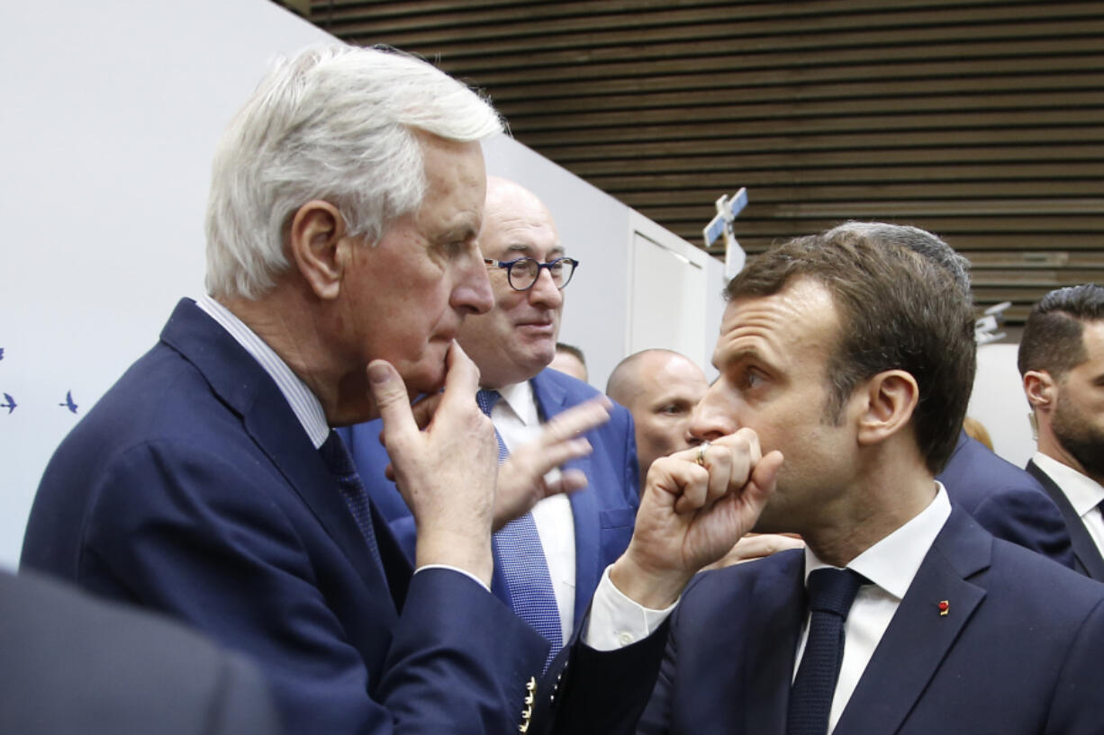 FILE - French President Emmanuel Macron, right, whispers to European Union chief Brexit negotiator Michel Barnier as he visits the International Agriculture Fair, in Paris, France. President Emmanuel Macron named the former EU Brexit negotiator as France&rsquo;s new prime minister on Thursday after more than 50 days of caretaker government.