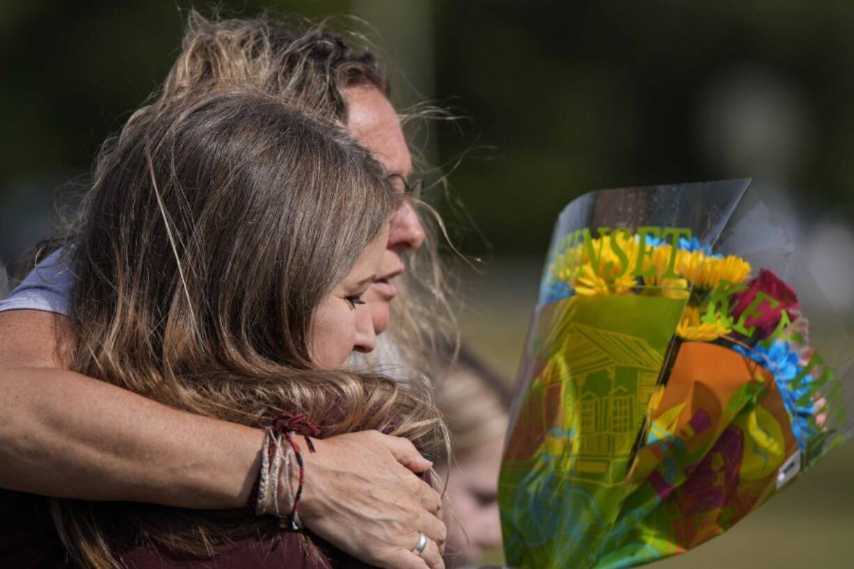 People embrace at a makeshift memorial after a shooting Wednesday at Apalachee High School, Thursday, Sept. 5, 2024, in Winder, Ga.