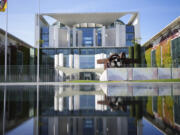 The Chancellery with the office of German Chancellor Olaf Scholz is reflected in a puddle in Berlin, Germany, Monday, Sept. 2, 2024.