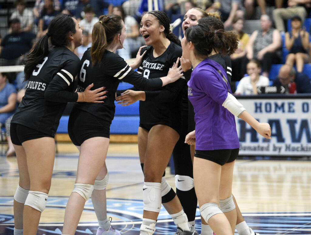 Heritage's Jordis Taylor (8) embraces teammate Harley McCants (6) after the Timberwolves earned a point against Hockinson during a non-leauge volleyball match on Thursday, Sept. 5, 2024, at Hockinson High School.