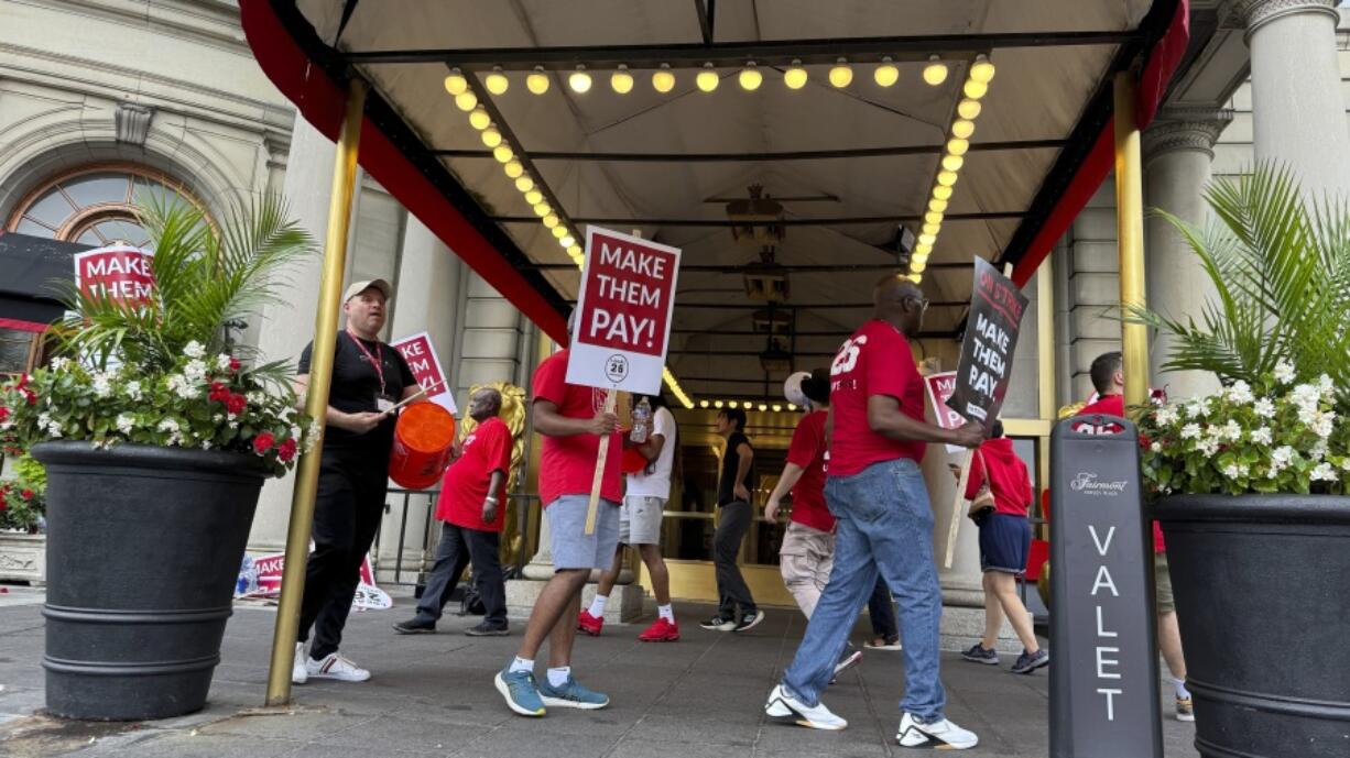 Hotel workers on strike chant and beat drums while picketing outside the Fairmont Copley Plaza hotel on Sunday in Boston.