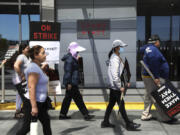 Hotel employees, local officials and members of Unite Here Local 2 union picket outside of the Grand Hyatt at SFO in South San Francisco, Calif., Monday, Sept. 2, 2024, during the second day of a three-day strike with hotel employees across the country.