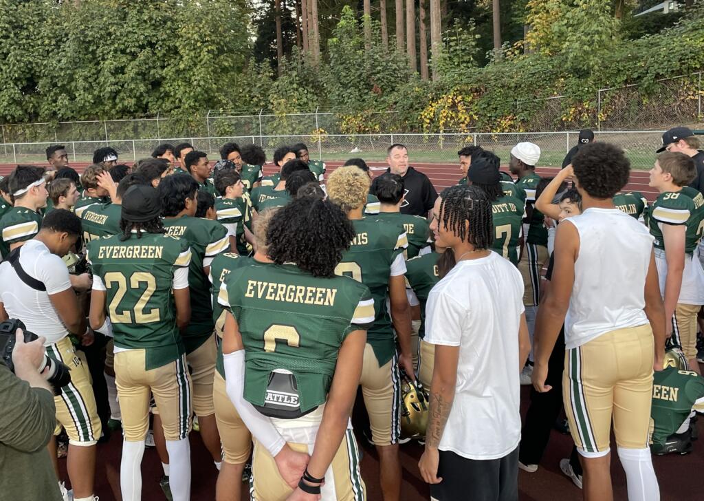 Evergreen football players huddle around head coach Christian Swain, middle, following the Plainsmen's 49-0 win over North Thurston on Friday, Sept. 20, 2024, at McKenzie Stadium.