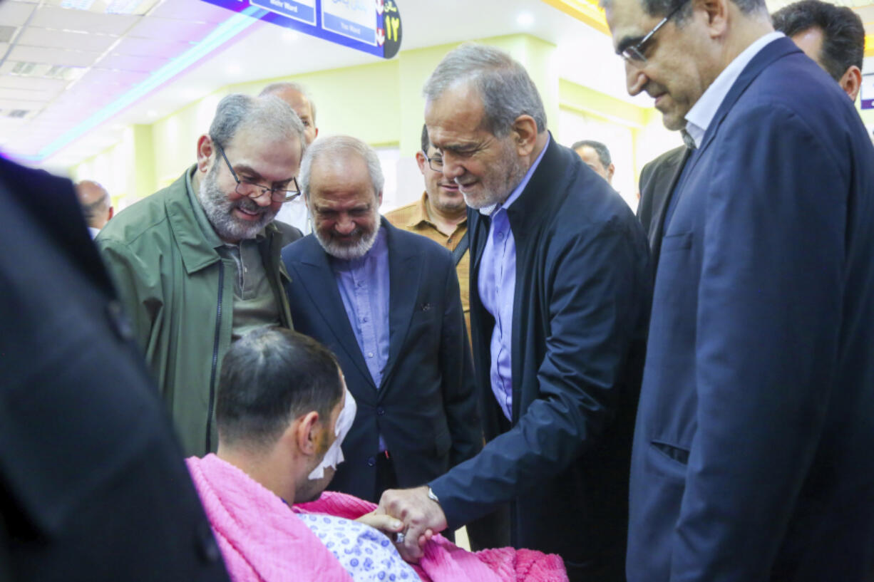 In this photo released by the Iranian Presidency Office, President Masoud Pezeshkian, second right, visits a victim of Lebanon&rsquo;s recent attacks at a hospital in Tehran, Iran, Friday, Sept. 20, 2024.