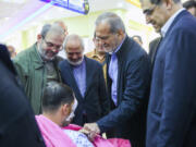 In this photo released by the Iranian Presidency Office, President Masoud Pezeshkian, second right, visits a victim of Lebanon&rsquo;s recent attacks at a hospital in Tehran, Iran, Friday, Sept. 20, 2024.