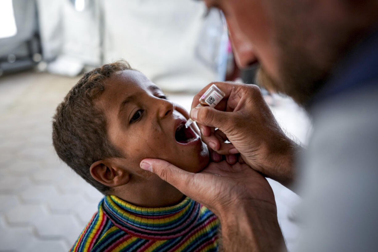 A health worker administers a polio vaccine to a child at a hospital in Deir al-Balah, central Gaza Strip, Sunday, Sept. 1, 2024.