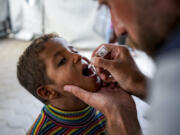 A health worker administers a polio vaccine to a child at a hospital in Deir al-Balah, central Gaza Strip, Sunday, Sept. 1, 2024.