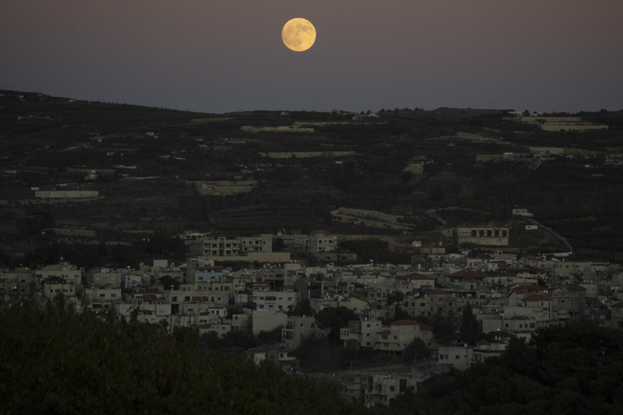 The supermoon rises behind the houses in Mas&#039;ade, a village in the Israeli-annexed Golan Heights, Tuesday, Sept. 17, 2024.