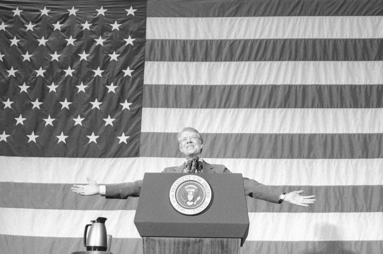 President Jimmy Carter acknowledges the applause of about 1,100 people gathered in the Elk City High School gym for a town meeting in Elk City, Okla., on March 24, 1979.