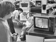 FILE - College student Chuck McManis watches President Jimmy Carter&rsquo;s nationally televised energy speech from a service station in Los Angeles, as a gas station attendant fills up a customer&rsquo;s car, July 15, 1979.