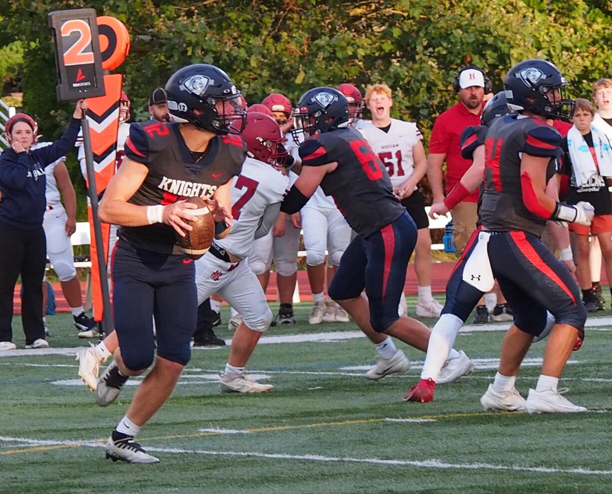 King's Way sophomore quarterback Owen Paulsen (12) rolls out while looking for a receiver downfield against Hoquiam on Friday, Sept. 13, 2024.