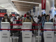 Travelers use kiosks to check in for flights in the Delta Airlines ticketing area at the Los Angeles International Airport in Los Angeles, Friday, Aug. 30, 2024. (AP Photo/Jae C.