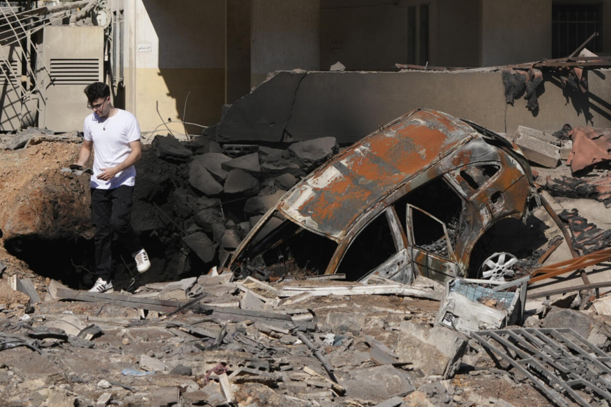 A man walks on rubble at the site of an Israeli airstrike in Beirut&#039;s southern suburbs, Sunday, Sept. 29, 2024.