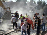 Emergency workers search for survivors at the scene of an Israeli airstrike in the town of Maisara, north of Beirut, Wednesday, Sept. 25, 2024.