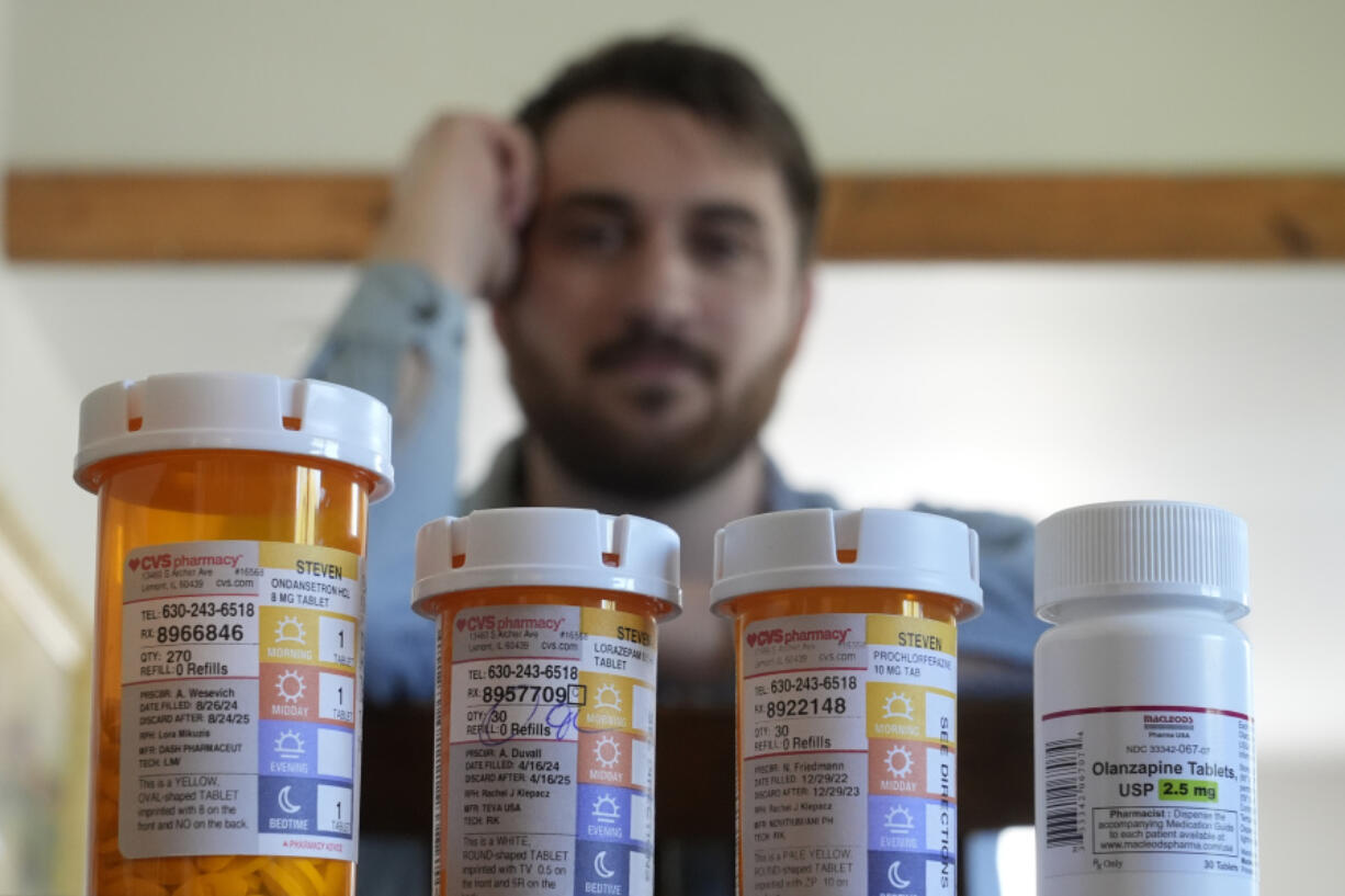 Cancer patient Steven Manetta sits for a portrait Monday, Sept. 9, 2024, in his Lemont, Ill., home with four of the five medicines he takes daily to battle the nausea from his chemotherapy.