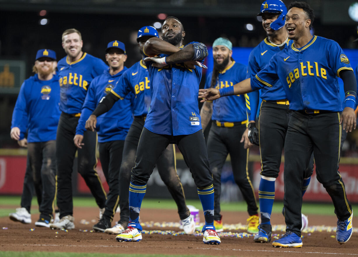 Seattle Mariners' Randy Arozarena, center, celebrates with teammates including Jorge Polanco, far right, and Julio Rodriguez, second from right, after a baseball game against the Texas Rangers, Saturday, Sept. 14, 2024, in Seattle.