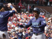 Seattle Mariners&#039; Jorge Polanco, right, is congratulated by teammate Justin Turner (2) after hitting a two-run home run during the fifth inning of a baseball game against the St. Louis Cardinals Sunday, Sept. 8, 2024, in St. Louis.