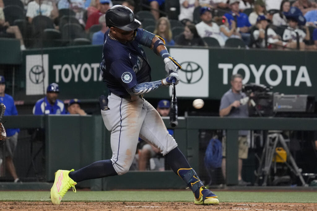 Seattle Mariners' Julio Rodríguez singles a line drive that scored teammate Dylan Moore during the sixth inning of a baseball game against the Texas Rangers, Saturday, Sept. 21, 2024, in Arlington, Texas.