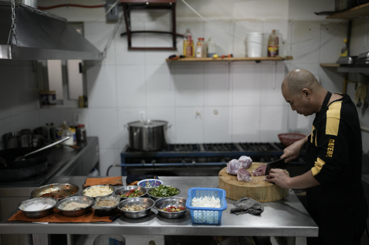 Li Ming prepares food at his son&rsquo;s Chinese food restaurant &ldquo;Nueve y media,&rdquo; in the Roma Sur neighborhood of Mexico City, Friday, July 5, 2024.