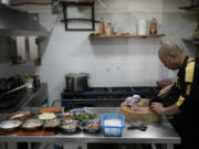 Li Ming prepares food at his son&rsquo;s Chinese food restaurant &ldquo;Nueve y media,&rdquo; in the Roma Sur neighborhood of Mexico City, Friday, July 5, 2024.