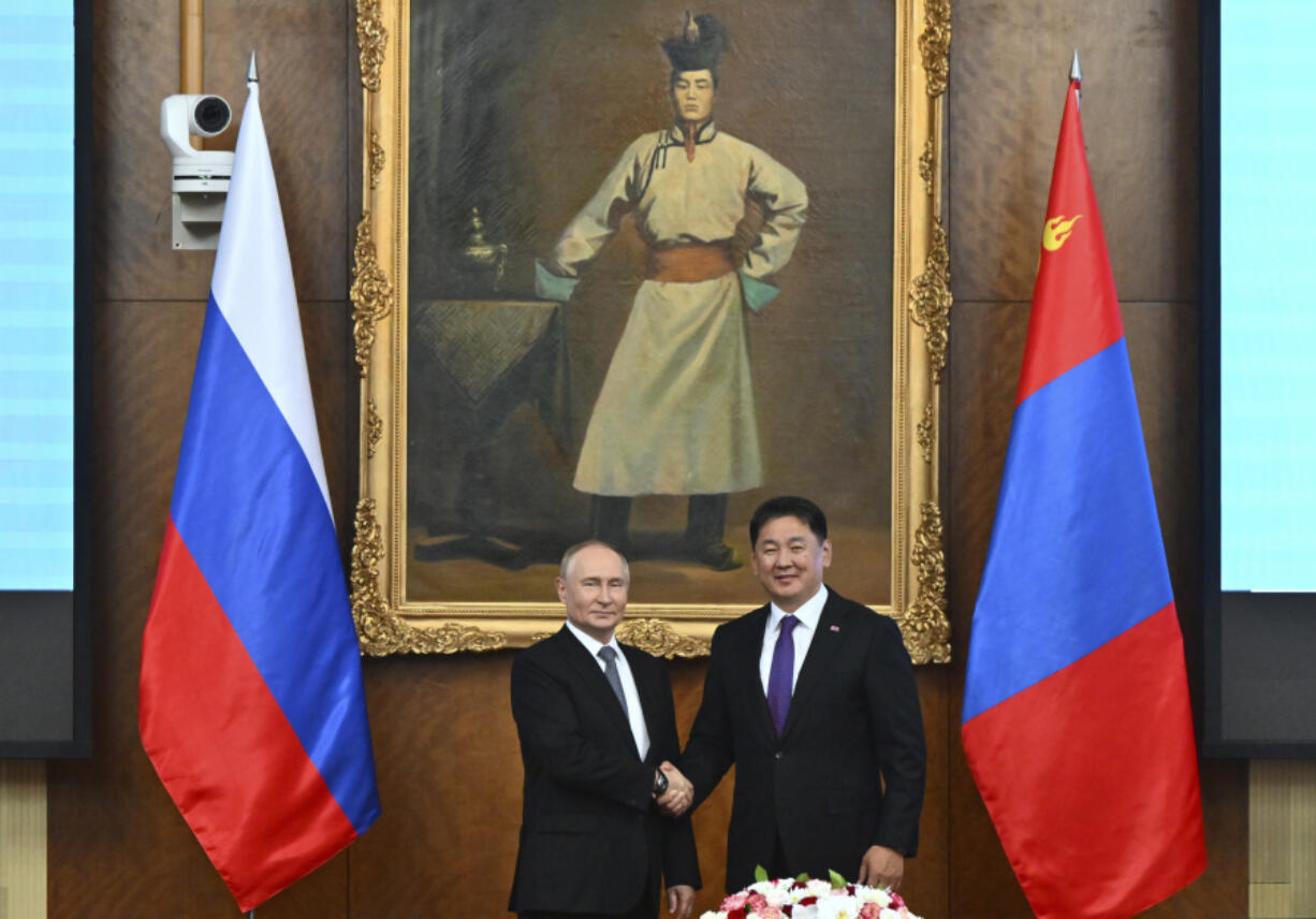 Russian President Vladimir Putin, left and Mongolian President Ukhnaagiin Khurelsukh shake hands as they pose for photos prior to the Russian-Mongolian talks at the Saaral Ordon Government Building in Ulaanbaatar, Mongolia, Tuesday, Sept. 3, 2024.