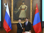 Russian President Vladimir Putin, left and Mongolian President Ukhnaagiin Khurelsukh shake hands as they pose for photos prior to the Russian-Mongolian talks at the Saaral Ordon Government Building in Ulaanbaatar, Mongolia, Tuesday, Sept. 3, 2024.