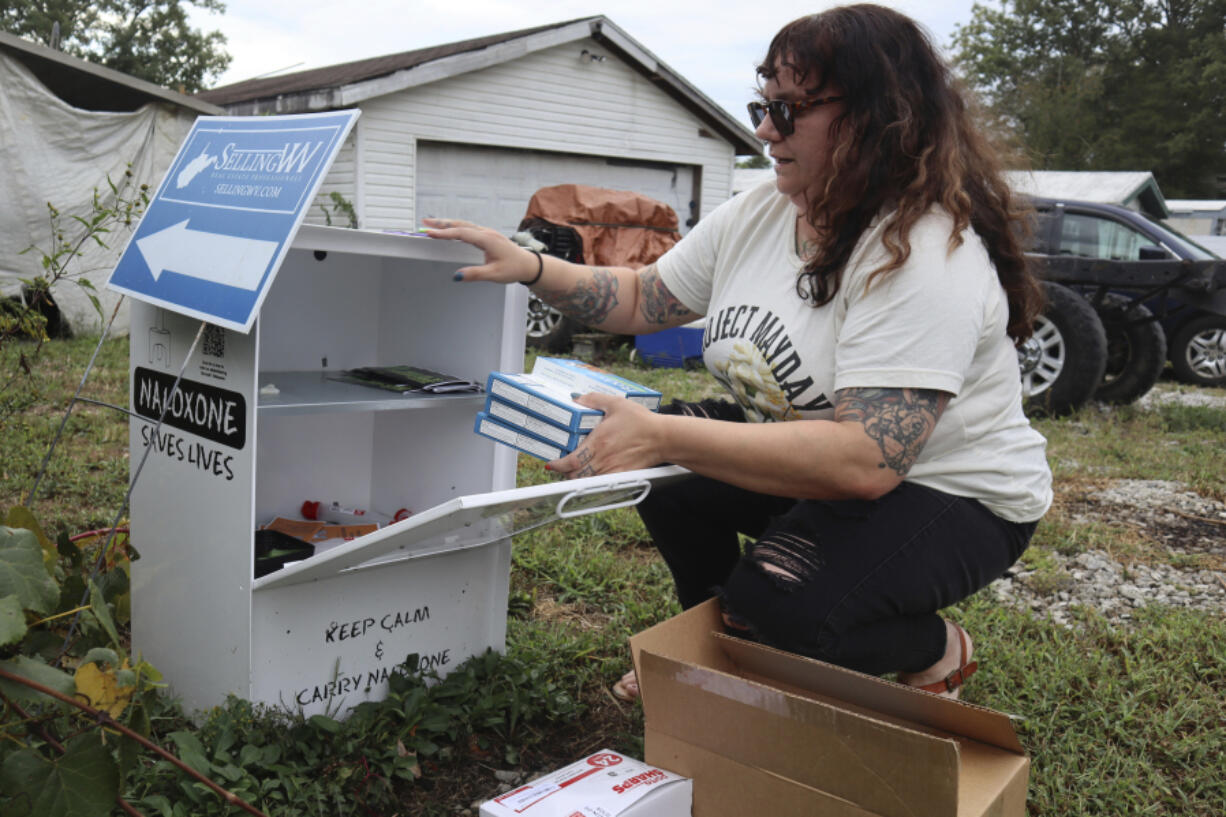 Tasha Withrow, a person in recovery and co-founder of harm reduction organization Project Mayday, refills a new naloxone distribution box in a residental neighborhood of Hurricane, W.Va. on Tuesday, Sept. 24, 2024.