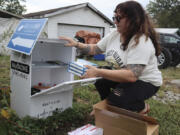 Tasha Withrow, a person in recovery and co-founder of harm reduction organization Project Mayday, refills a new naloxone distribution box in a residental neighborhood of Hurricane, W.Va. on Tuesday, Sept. 24, 2024.