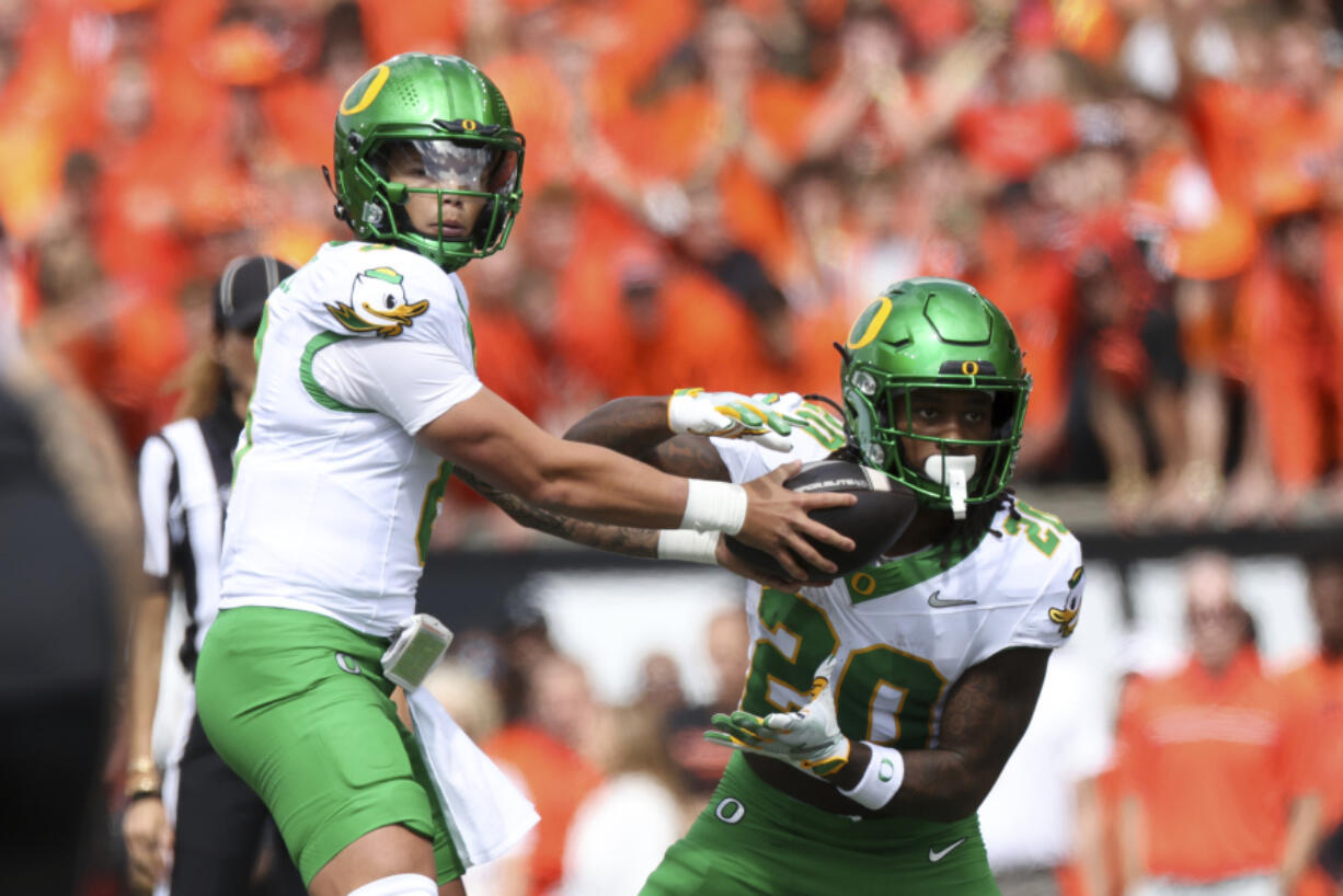 Oregon quarterback Dillon Gabriel (8) hands off the ball to running back Jordan James (20) during the first half of an NCAA football game, Saturday, Sept. 14, 2024, in Corvallis, Ore.