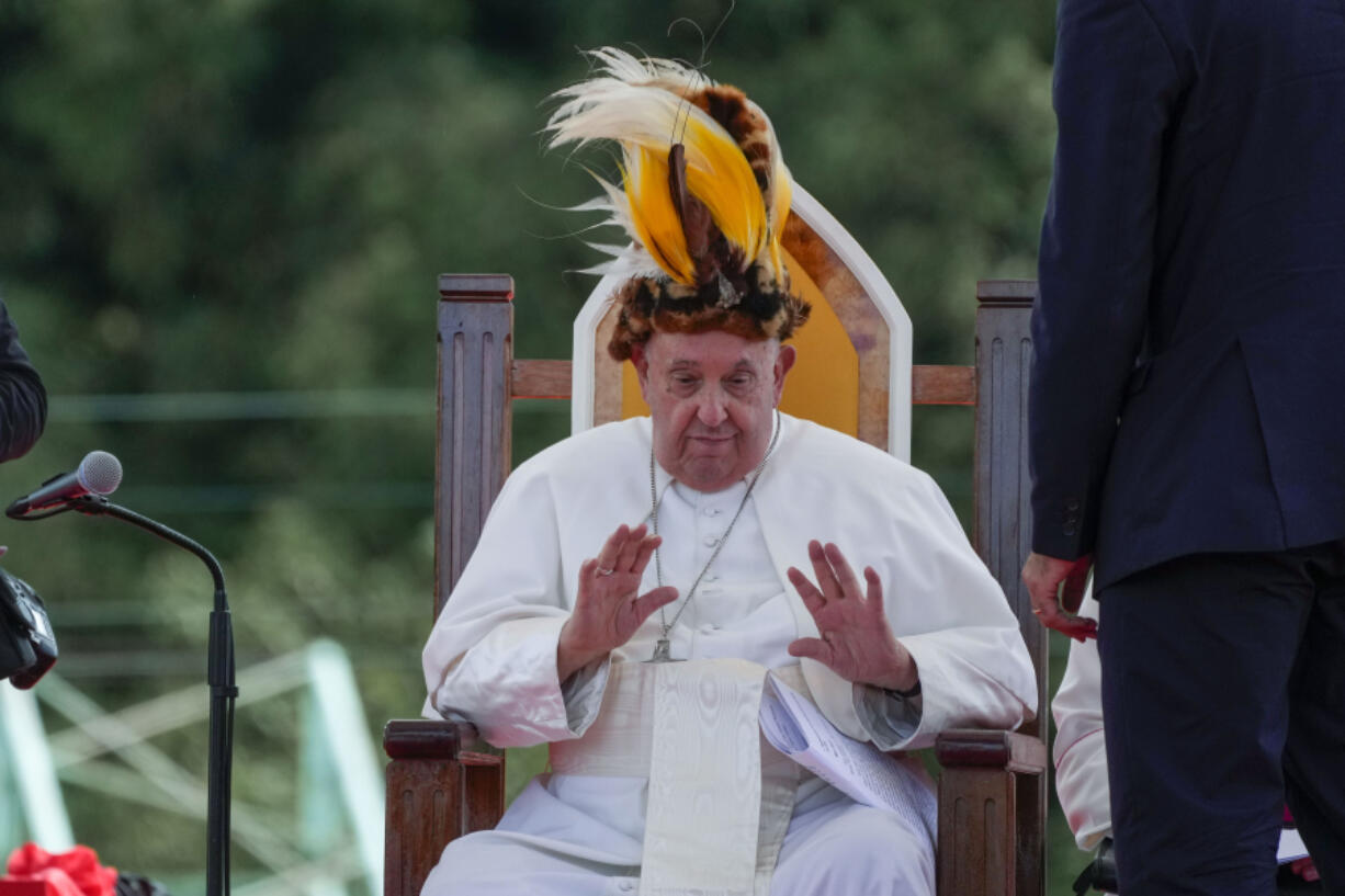 Pope Francis receives a traditional hat during a meeting with faithful in Vanimo, Papua New Guinea, Sunday, Sept. 8, 2024.