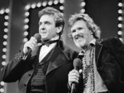 FILE - Country stars Johnny Cash, left and Kris Kristofferson sing during the Country Music Awards in Nashville, Tenn., Oct. 1983. Kristofferson, a Rhodes scholar with a deft writing style and rough charisma who became a country music superstar and A-list Hollywood actor, has died Saturday, Sept. 28, 2024.