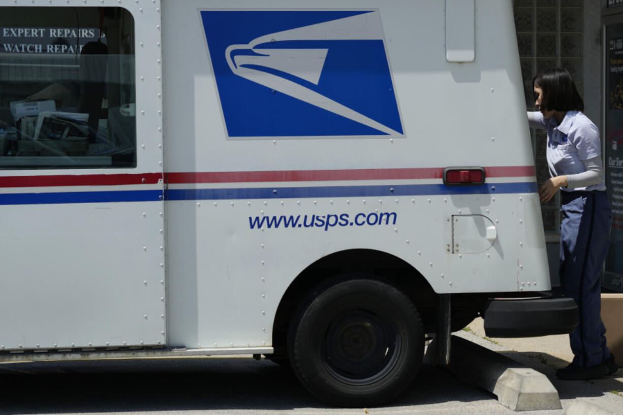 FILE - A U.S. Postal Service employee works outside as she makes deliveries in Northbrook, Ill., Monday, June 3, 2024. (AP Photo/Nam Y.