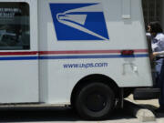 FILE - A U.S. Postal Service employee works outside as she makes deliveries in Northbrook, Ill., Monday, June 3, 2024. (AP Photo/Nam Y.