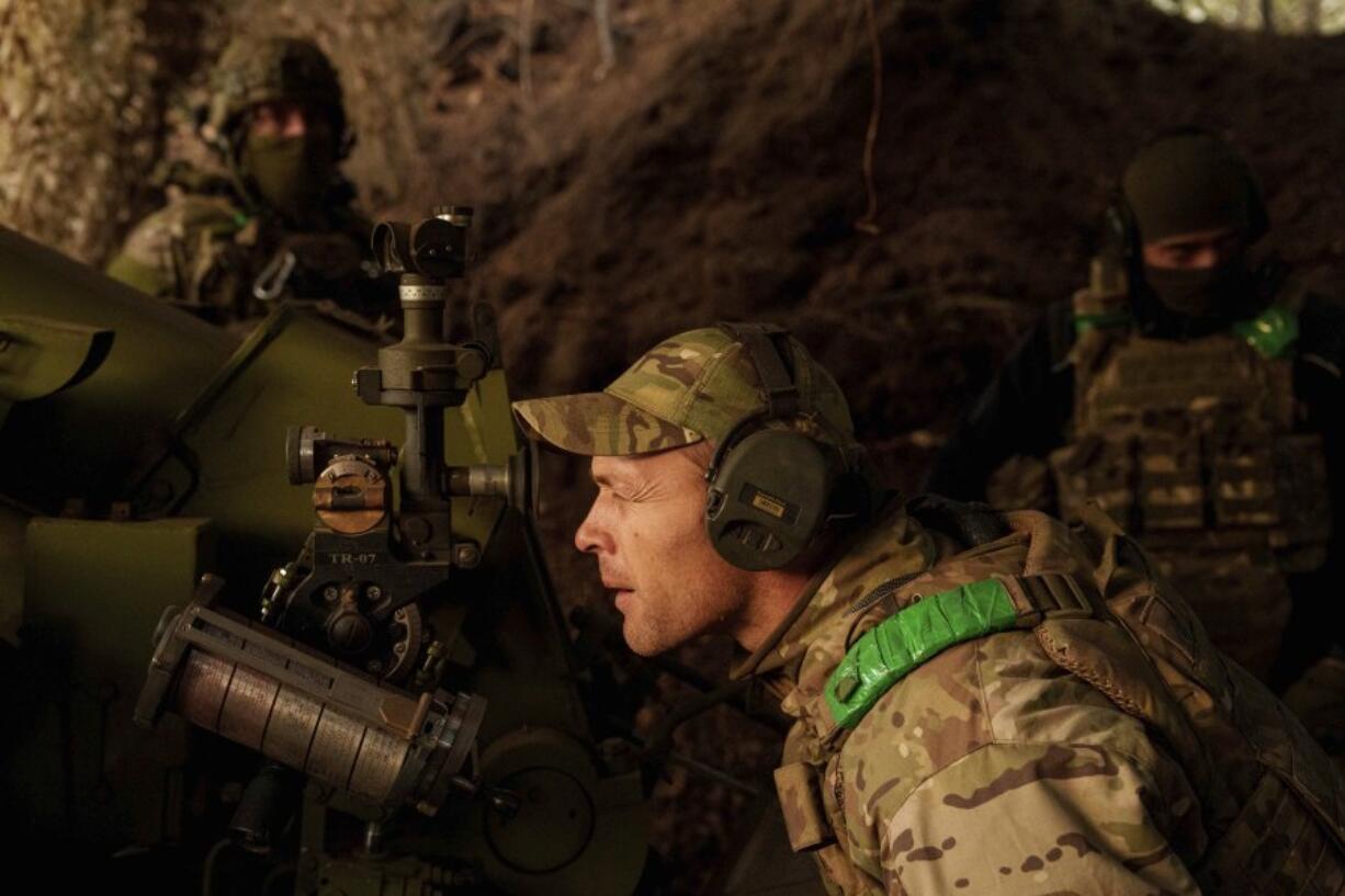 A Ukrainian serviceman of Liut brigade aims his D-30 artillery cannon during firing towards Russian positions near Toretsk, Donetsk region, Ukraine, Sunday Sept. 22, 2024.